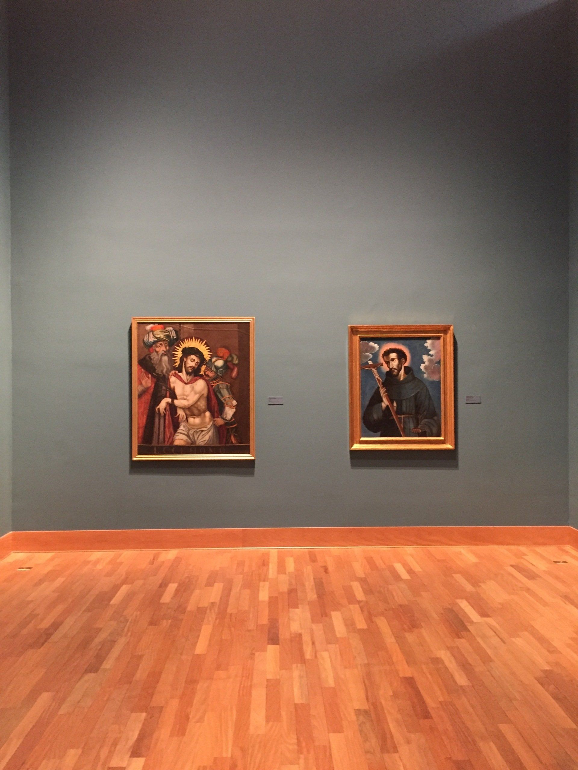 Dos cuadros están colgados en una pared en un museo.