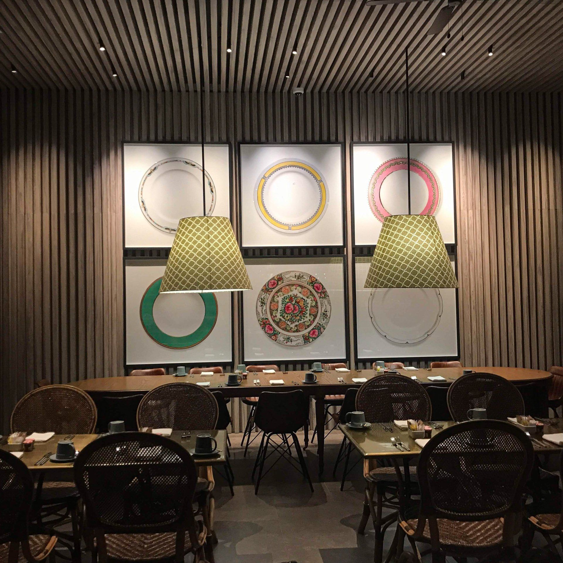 Un restaurante con mesas y sillas y una pared con círculos.