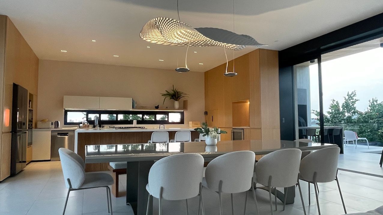 Un comedor con una mesa y sillas y una cocina al fondo.