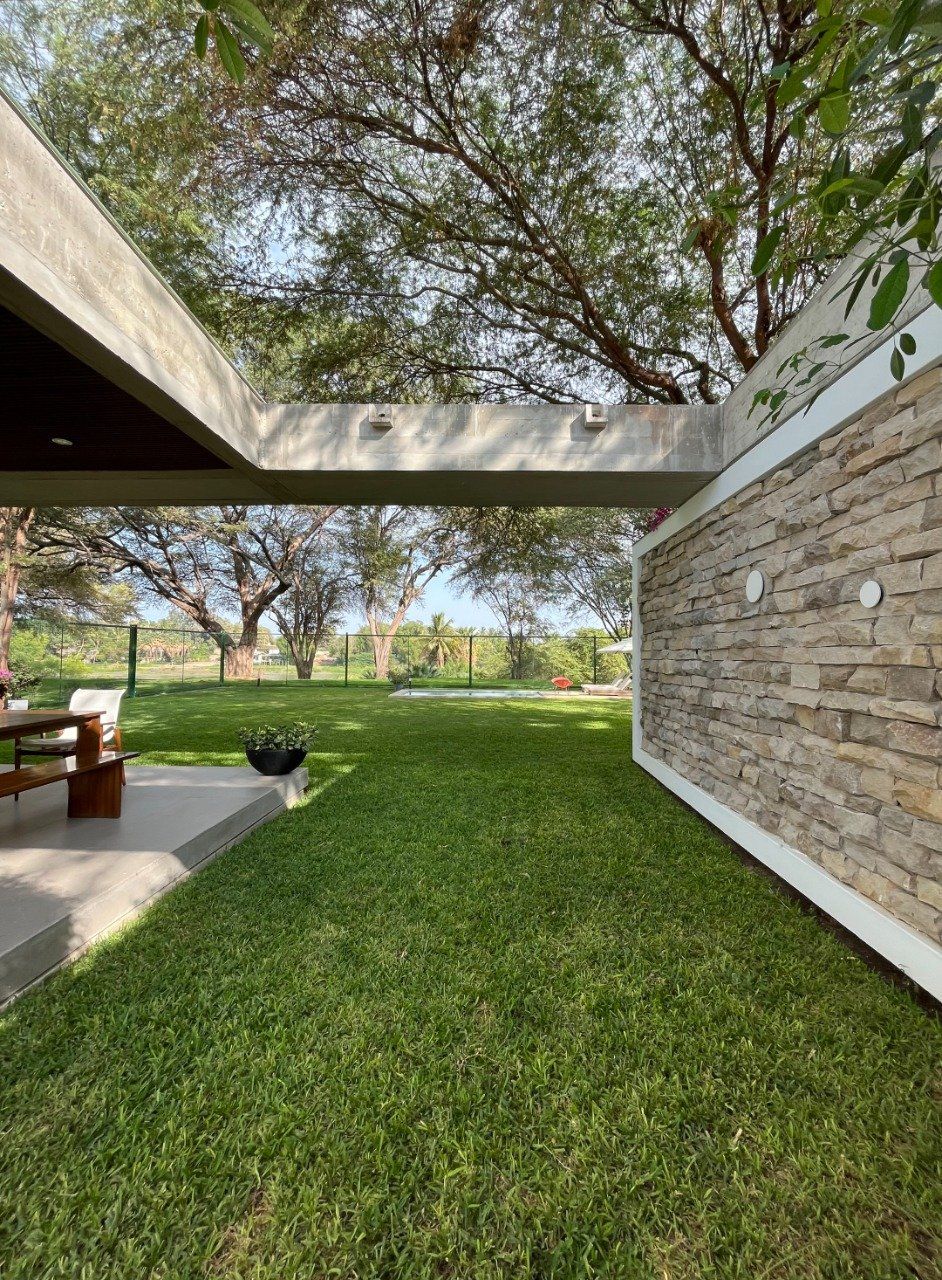 Una casa con una pared de ladrillos y un exuberante césped verde.