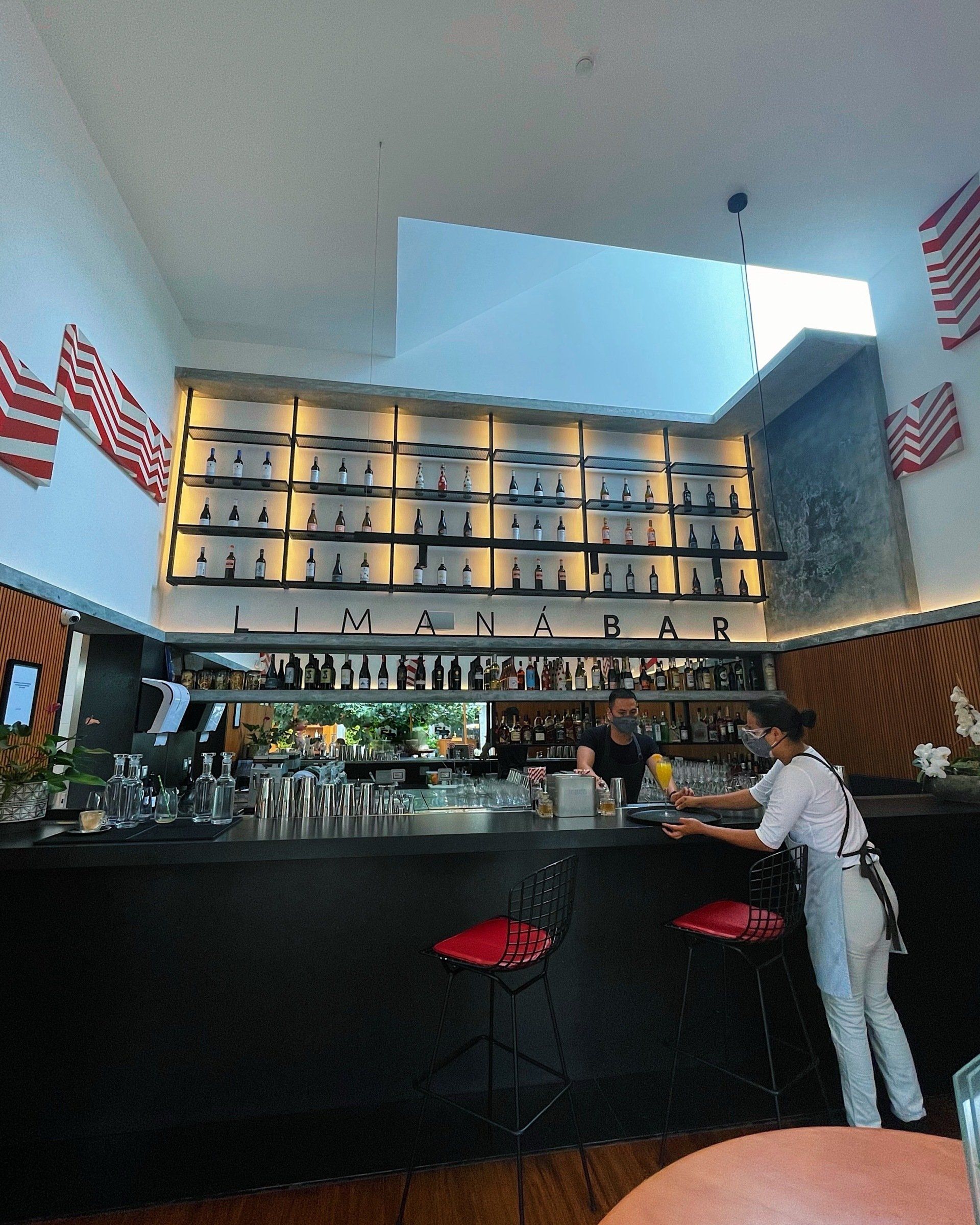 Un hombre está de pie en una barra de un restaurante.