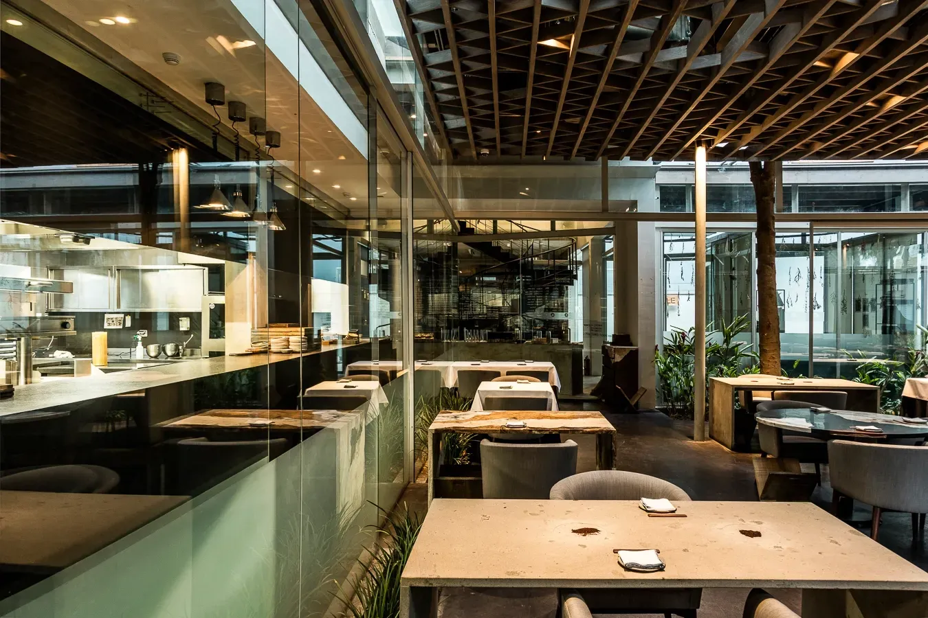 Un restaurante con mesas y sillas y una cocina al fondo.