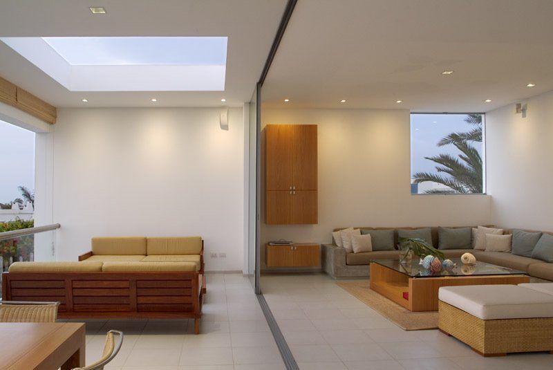 Una sala de estar con muchos muebles y un tragaluz.