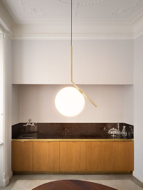 Una cocina con gabinetes de madera y una lámpara colgante que cuelga del techo.