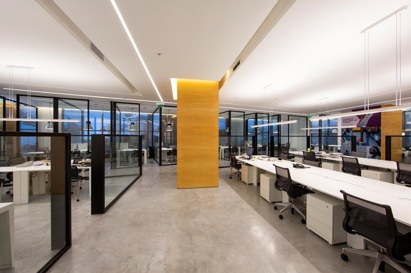 Una oficina grande con muchos escritorios y sillas.