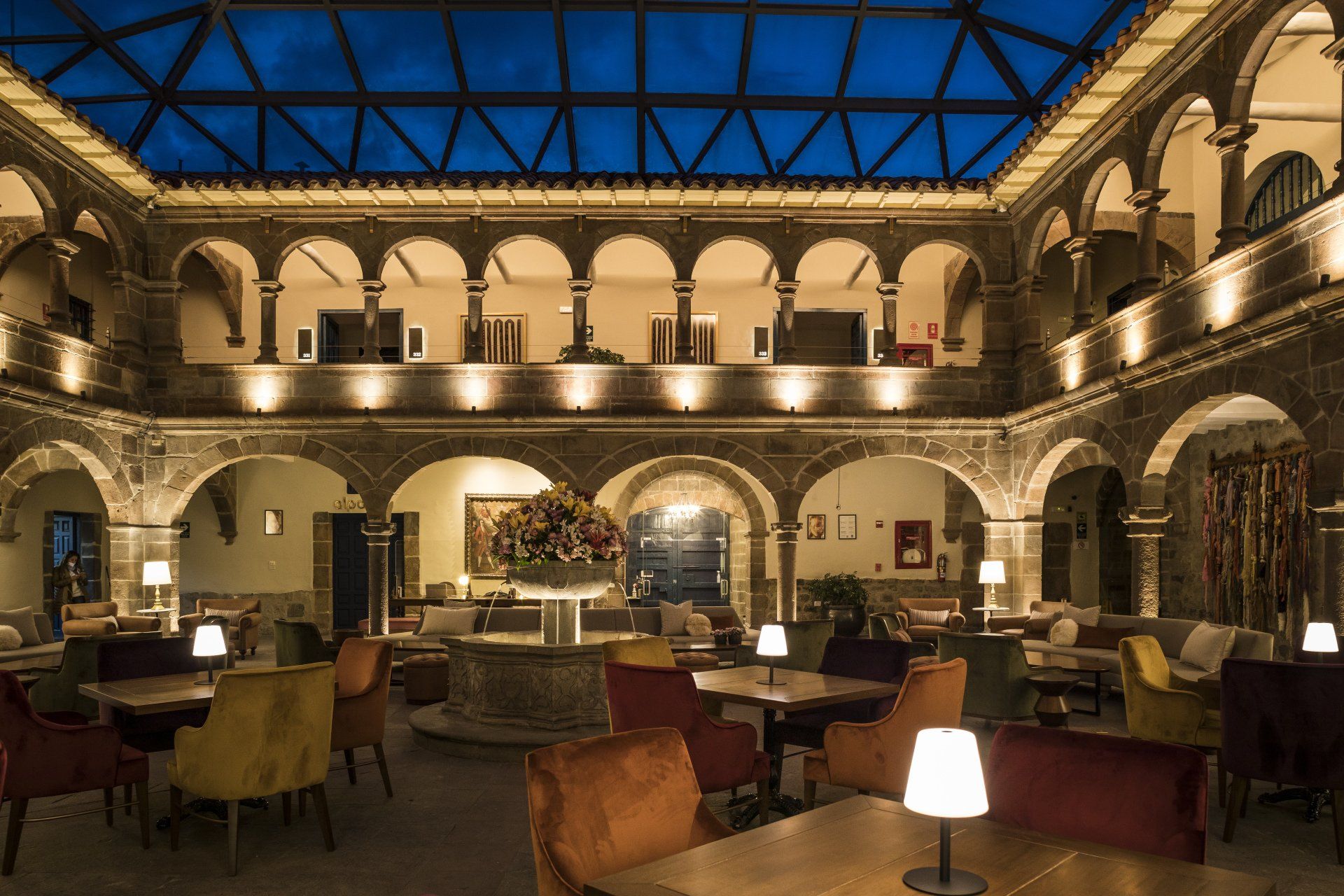 Una gran sala con arcos, mesas y sillas.