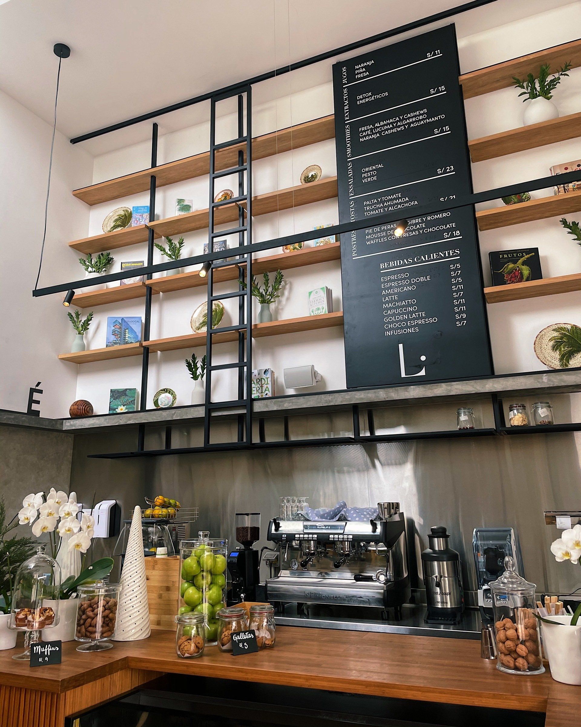Una cocina con estantes de madera y una pizarra en la pared.
