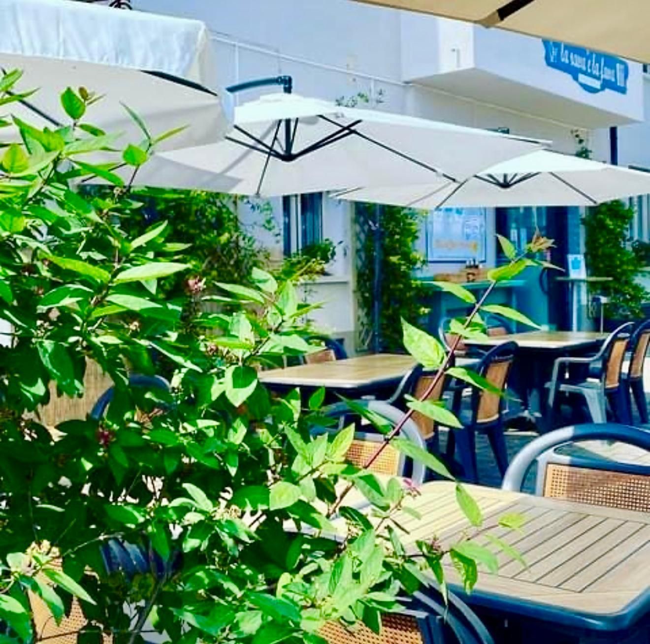 Un ristorante con tavoli e sedie sotto gli ombrelloni