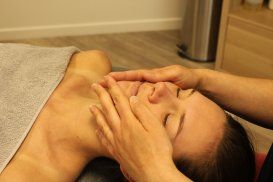 Une femme reçoit un massage du visage dans un spa.