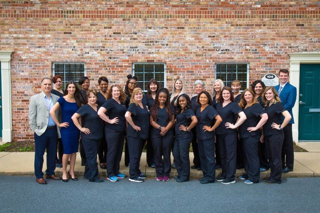 A Large Group Of People In Front Of A Brick Building — Clinton, MD — Hamam & Lamb DDS PA