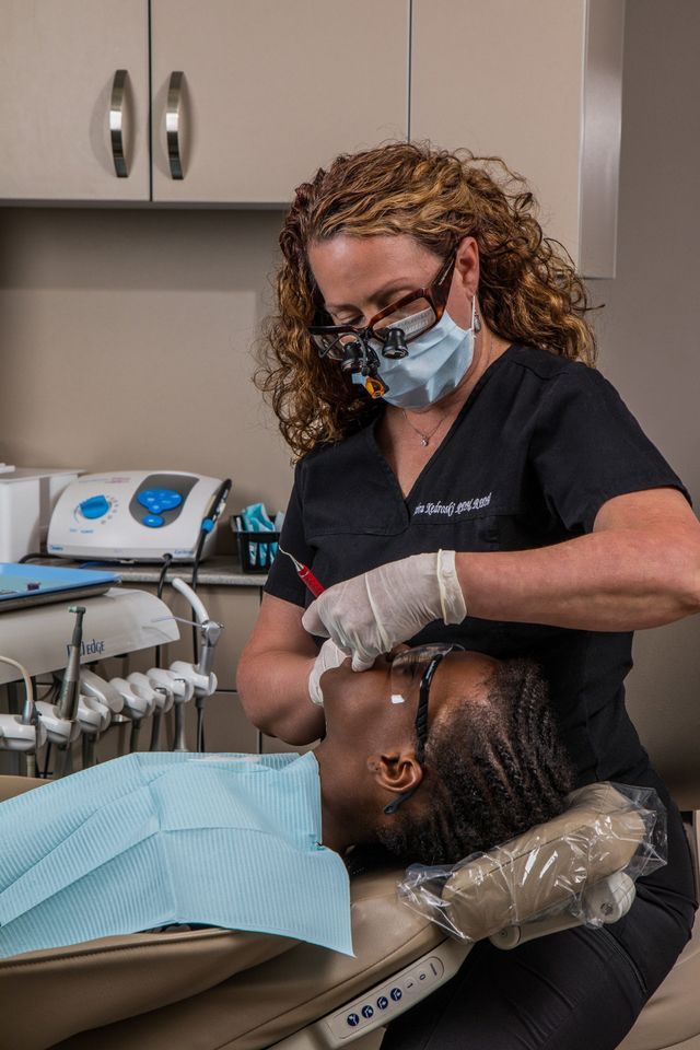 A Female Dentist Is Examining A Patient's Teeth — Clinton, MD — Hamam & Lamb DDS PA