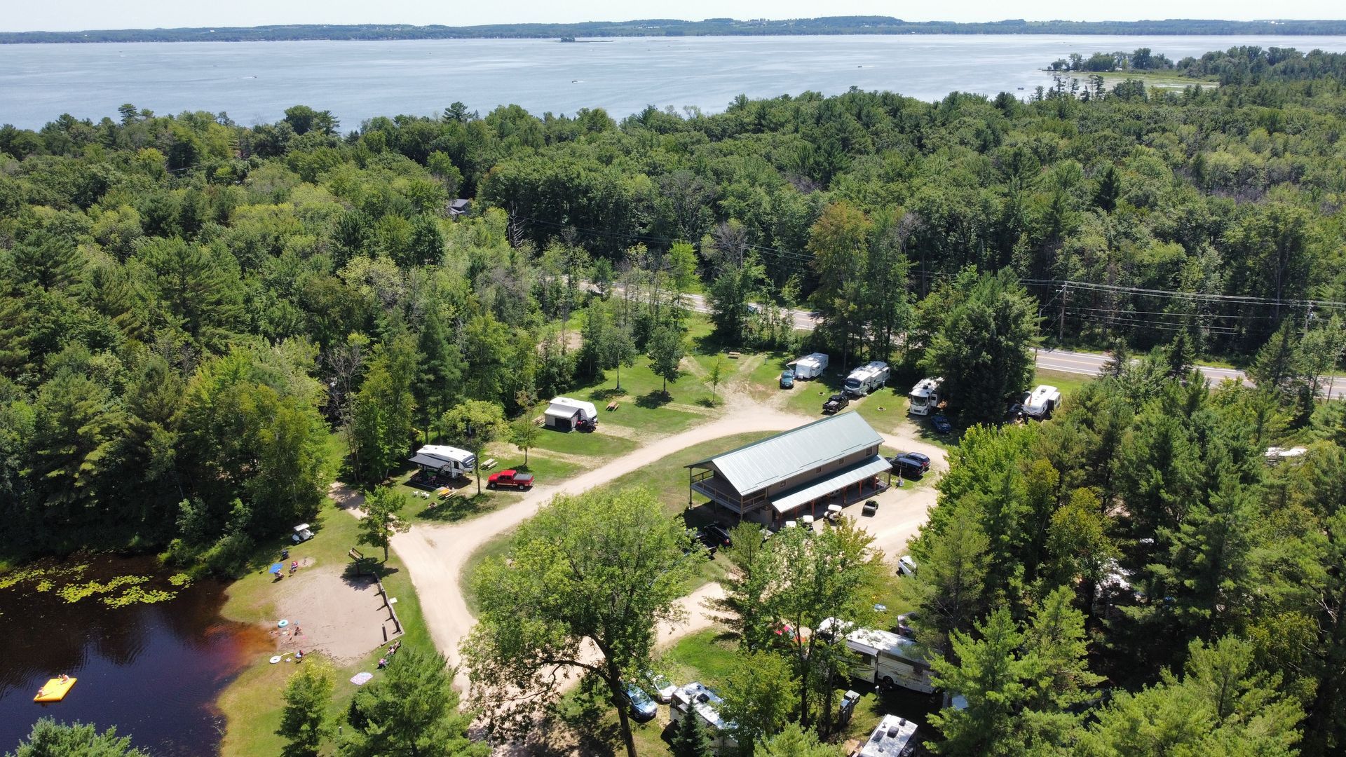 An aerial view of a campground surrounded by trees and a body of water.