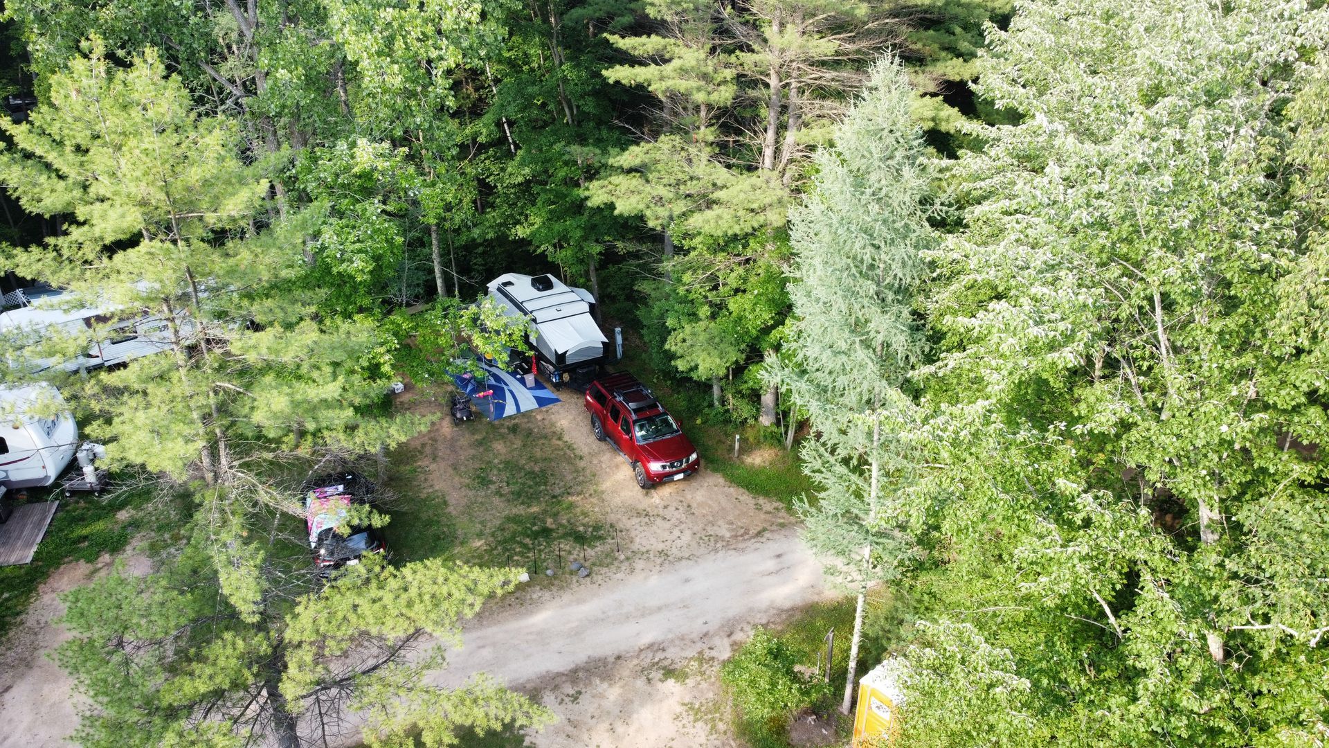 An aerial view of a rv parked in the middle of a forest.