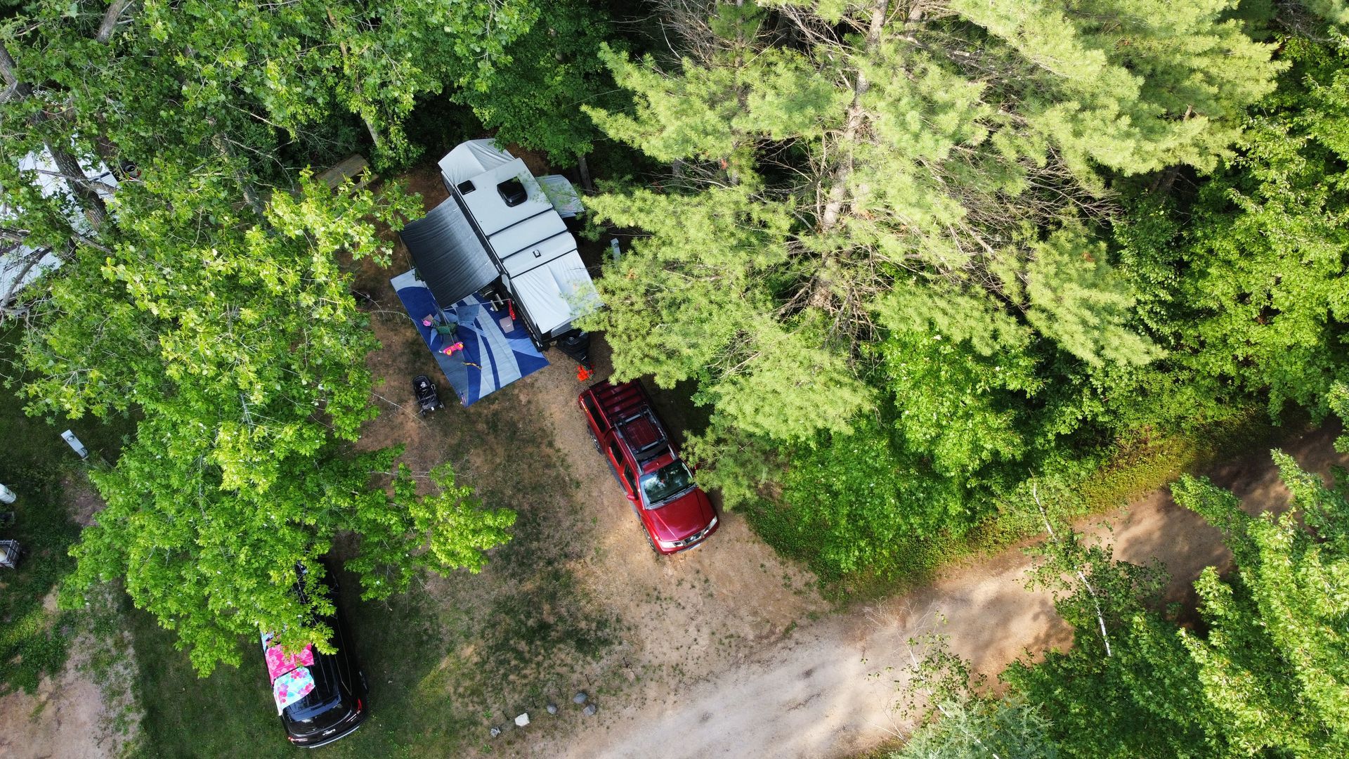 An aerial view of a rv parked in the woods.