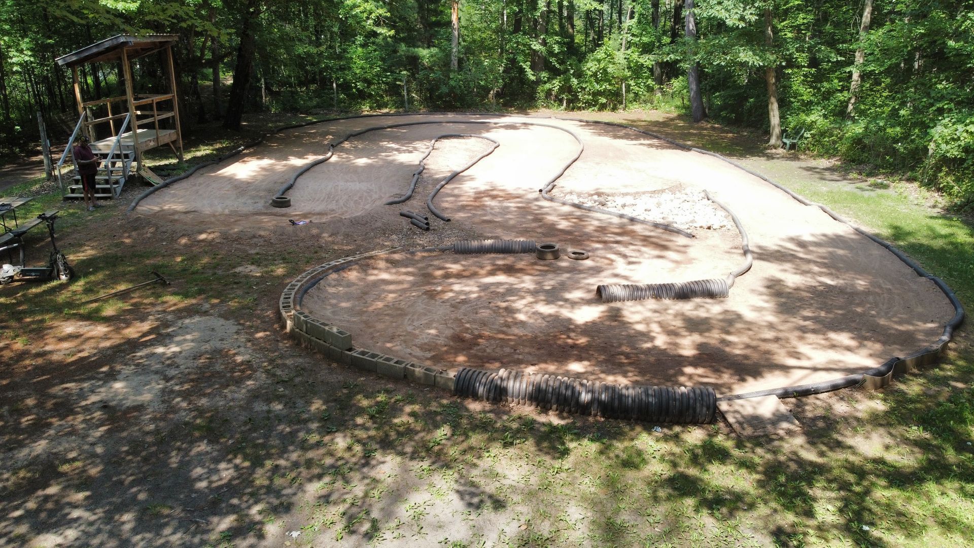 An aerial view of a dirt track in the middle of a forest.