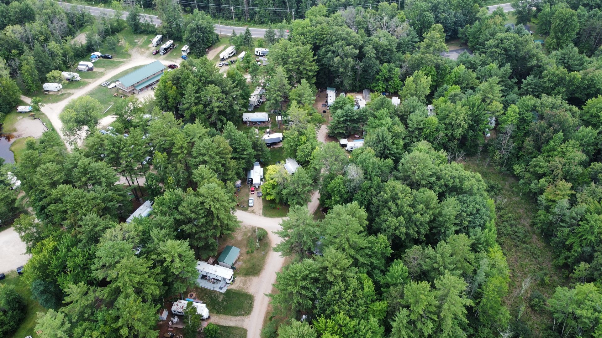 An aerial view of a campground surrounded by trees and houses.