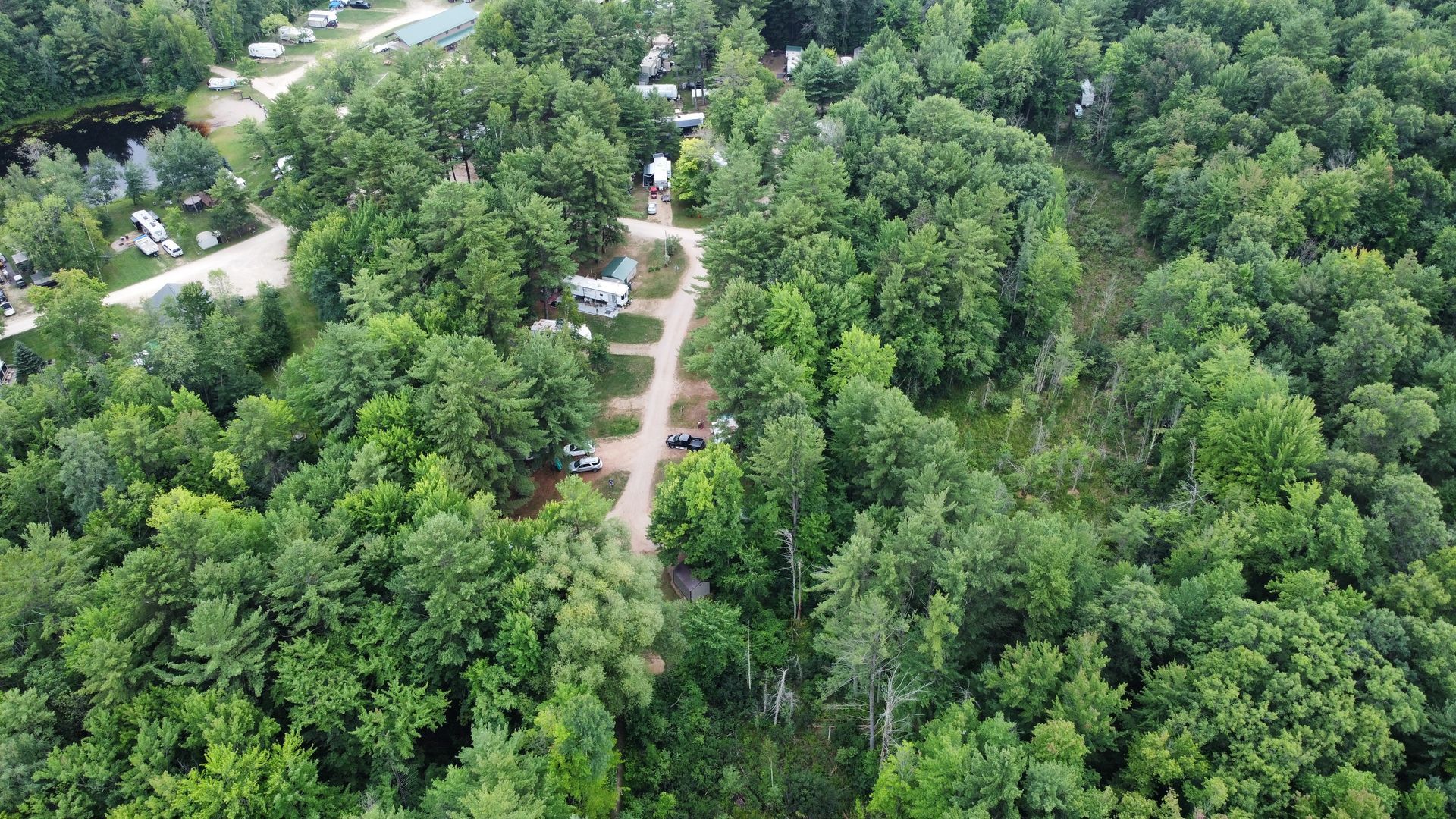 An aerial view of a campground surrounded by trees and a road.