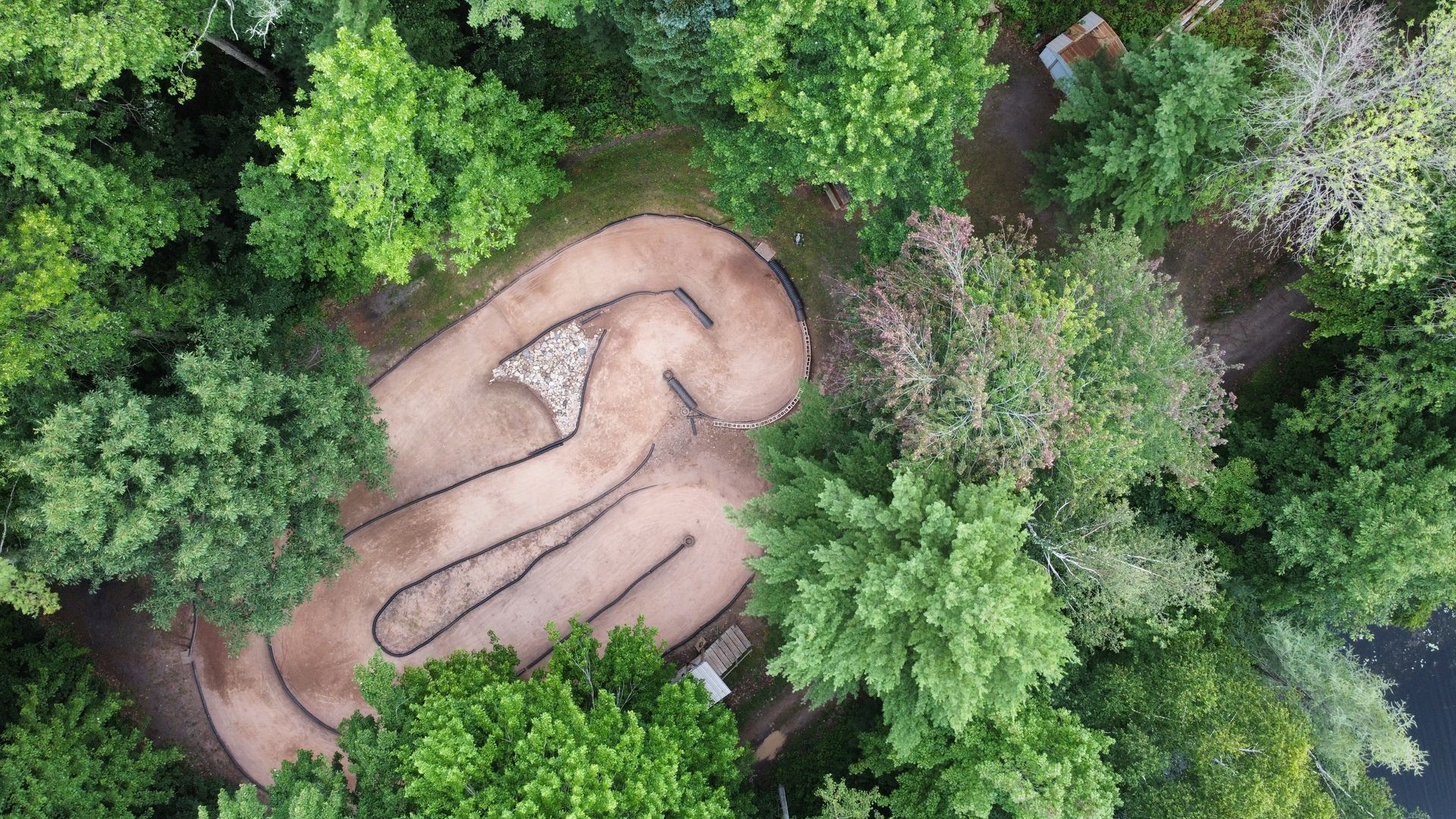 An aerial view of a dirt bike track in the middle of a forest.