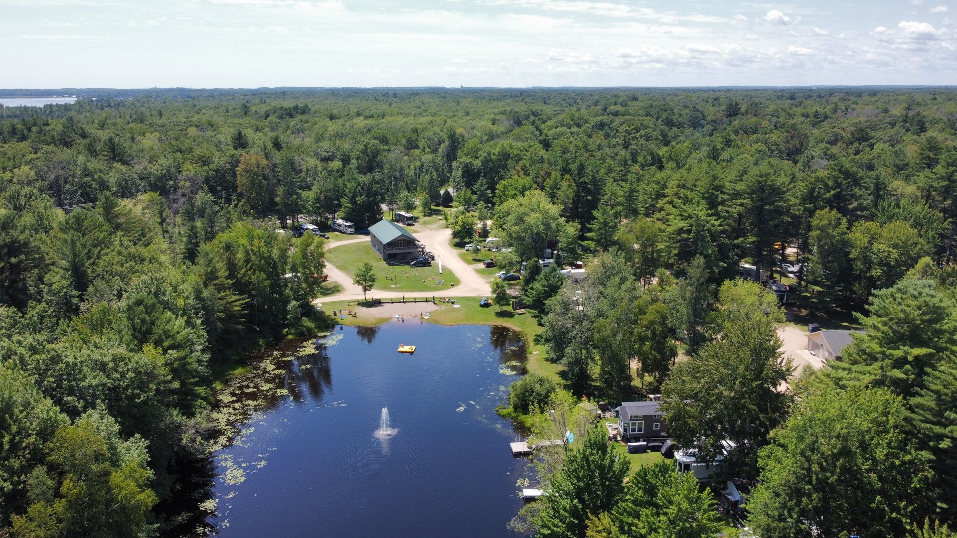 An aerial view of a lake surrounded by trees and houses.