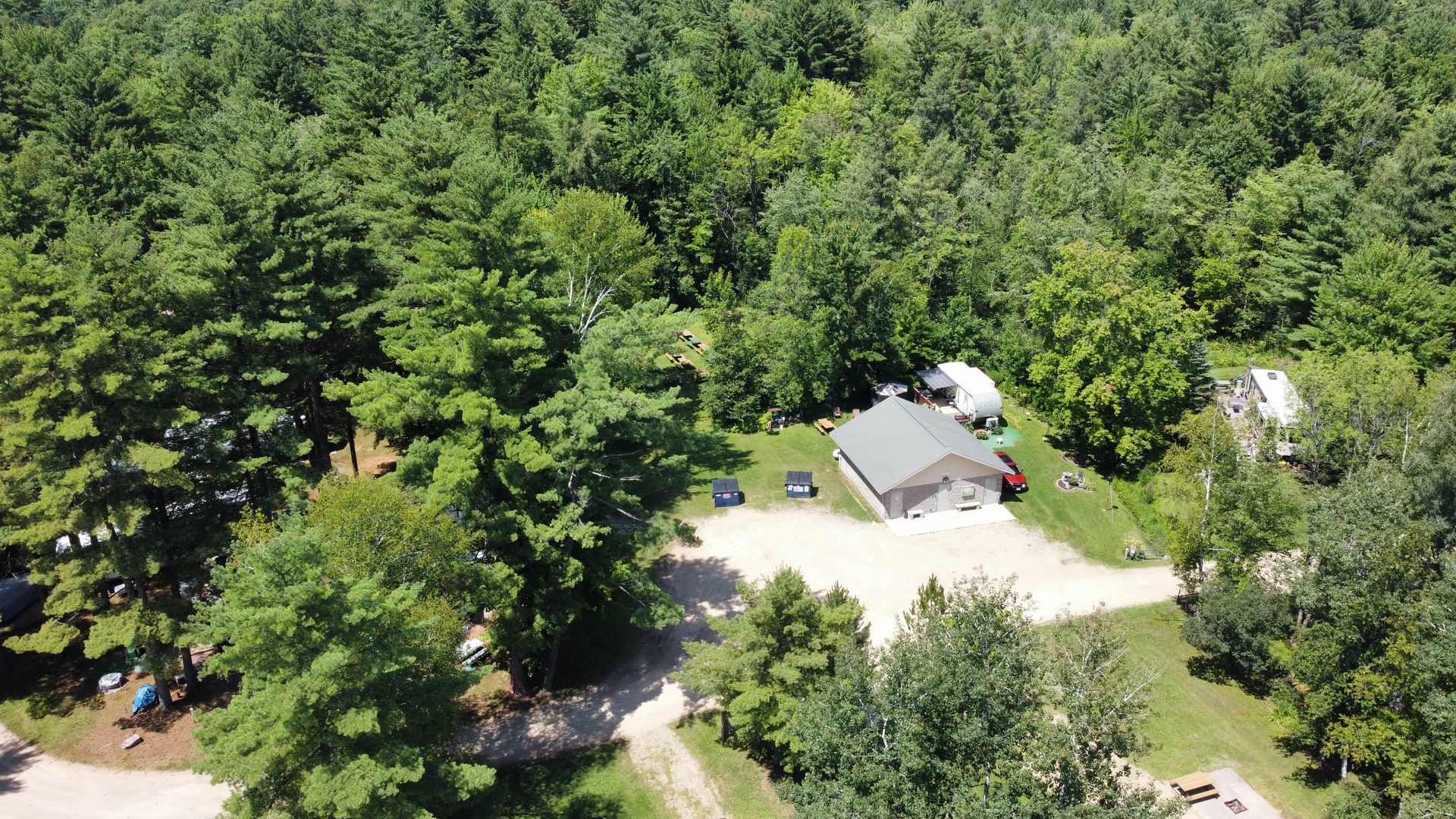 An aerial view of a house in the middle of a forest.