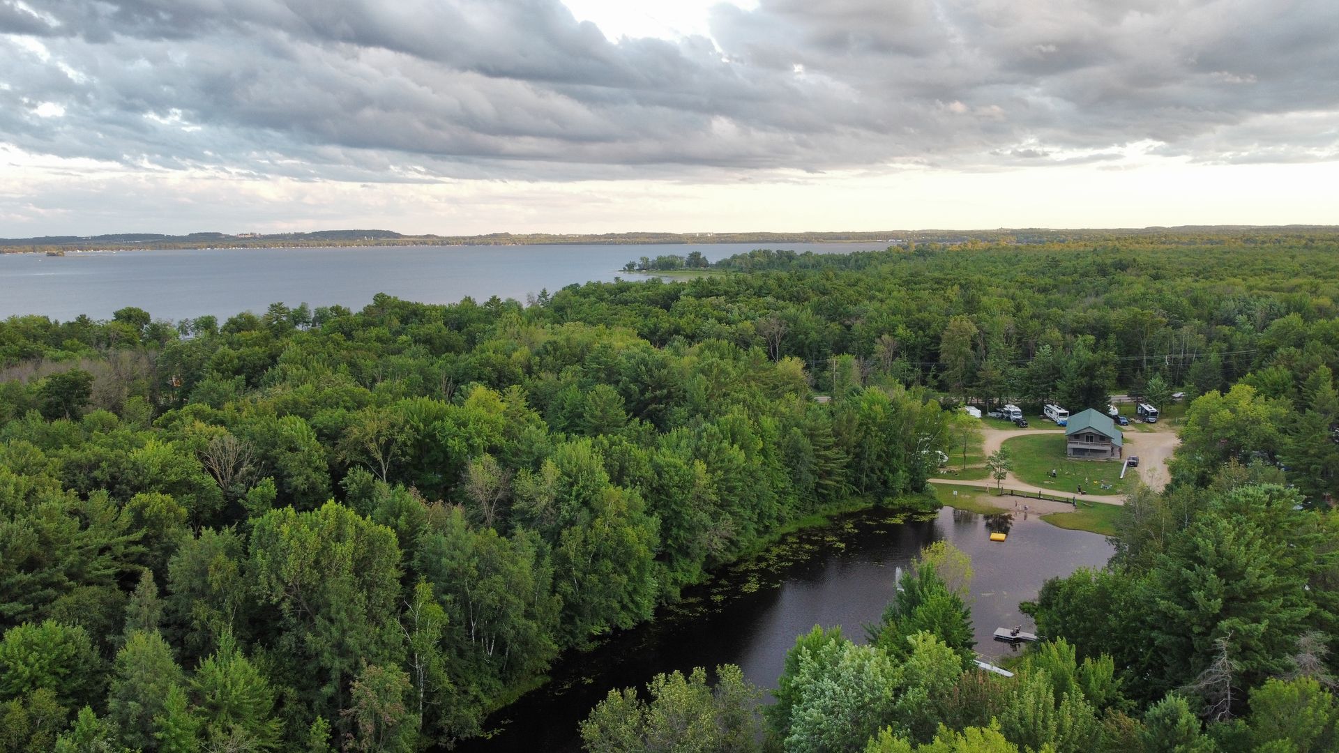 An aerial view of a river surrounded by trees and a lake.