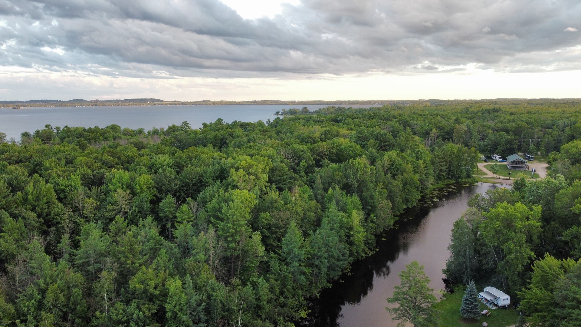 An aerial view of a river running through a lush green forest.