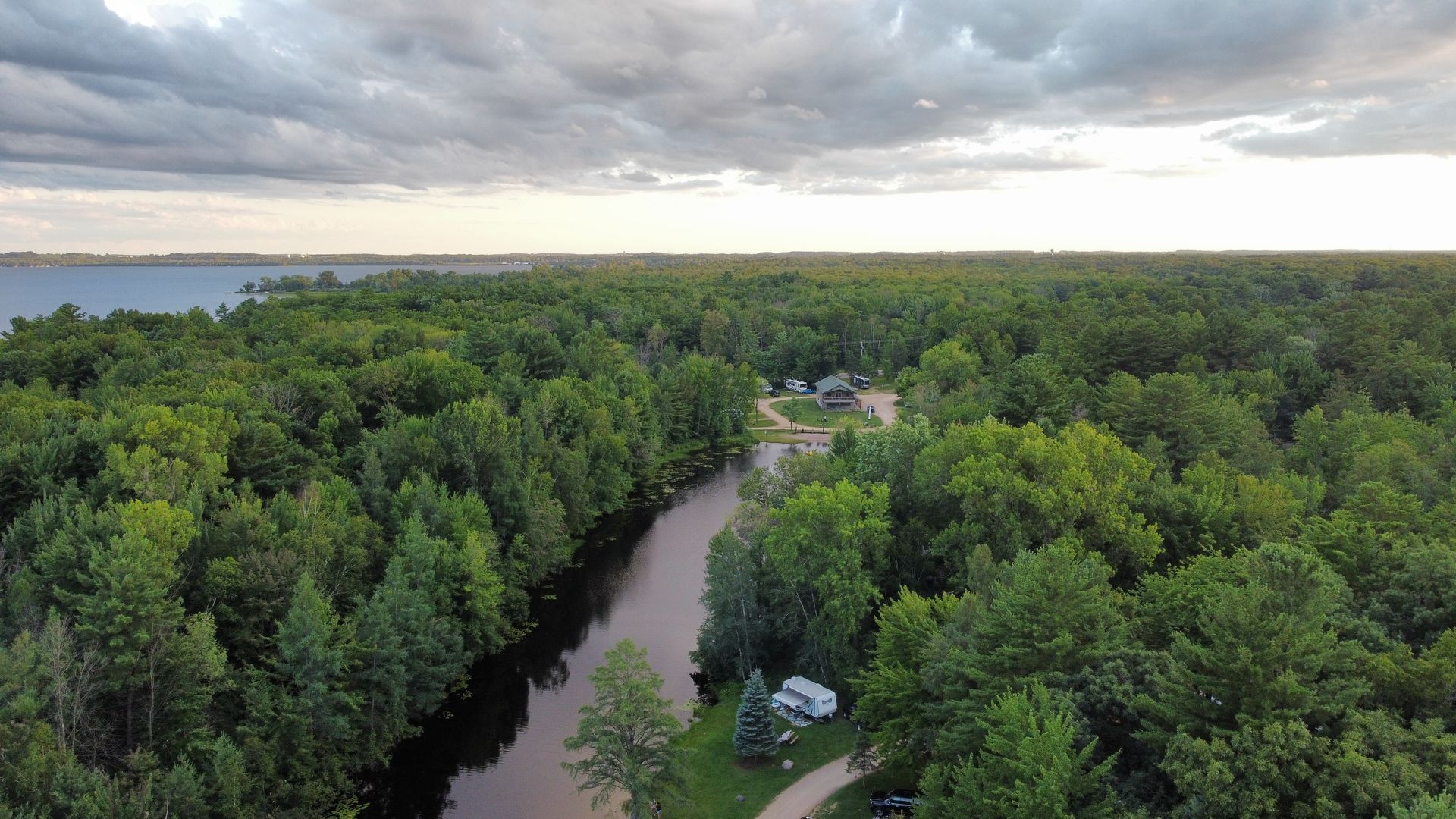 An aerial view of a river running through a lush green forest.
