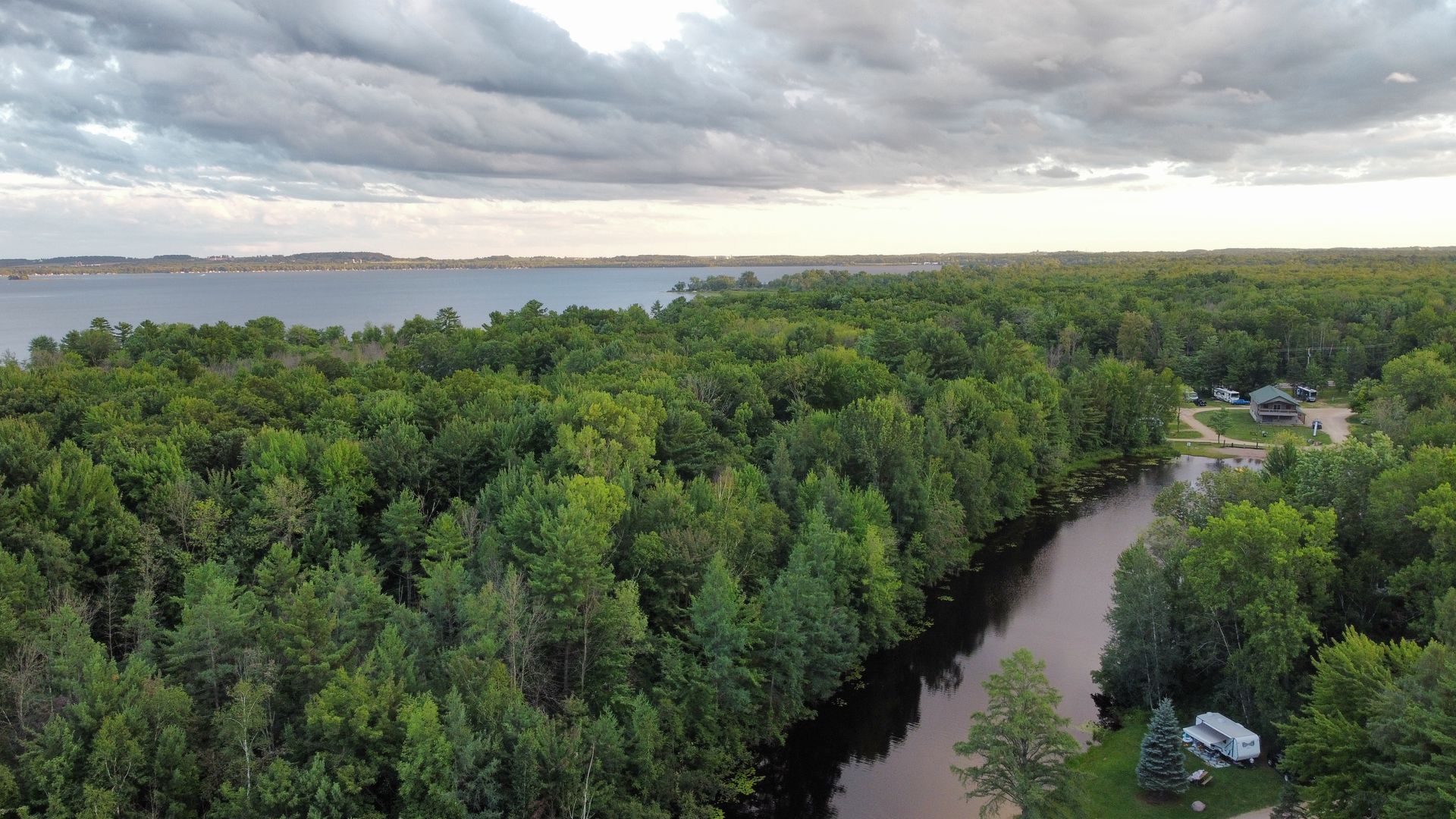 An aerial view of a river surrounded by trees and a lake.