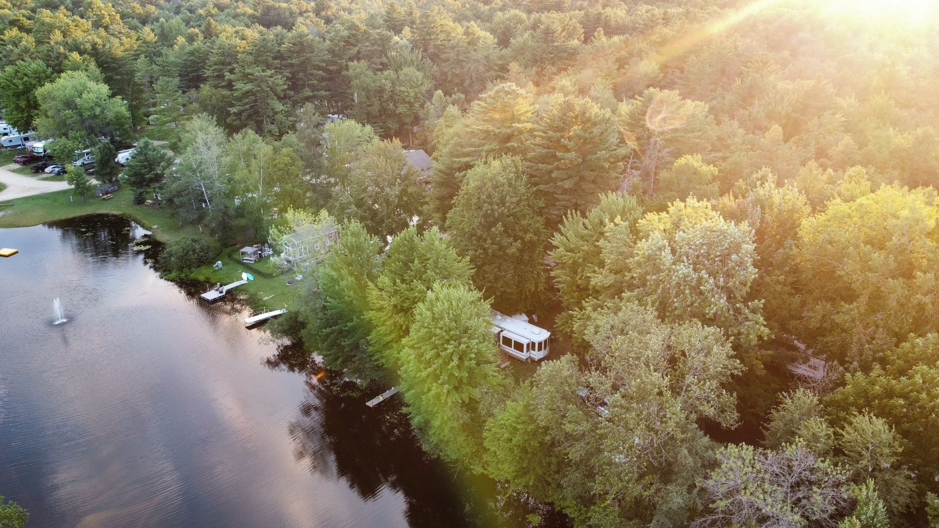 An aerial view of a lake surrounded by trees and houses.
