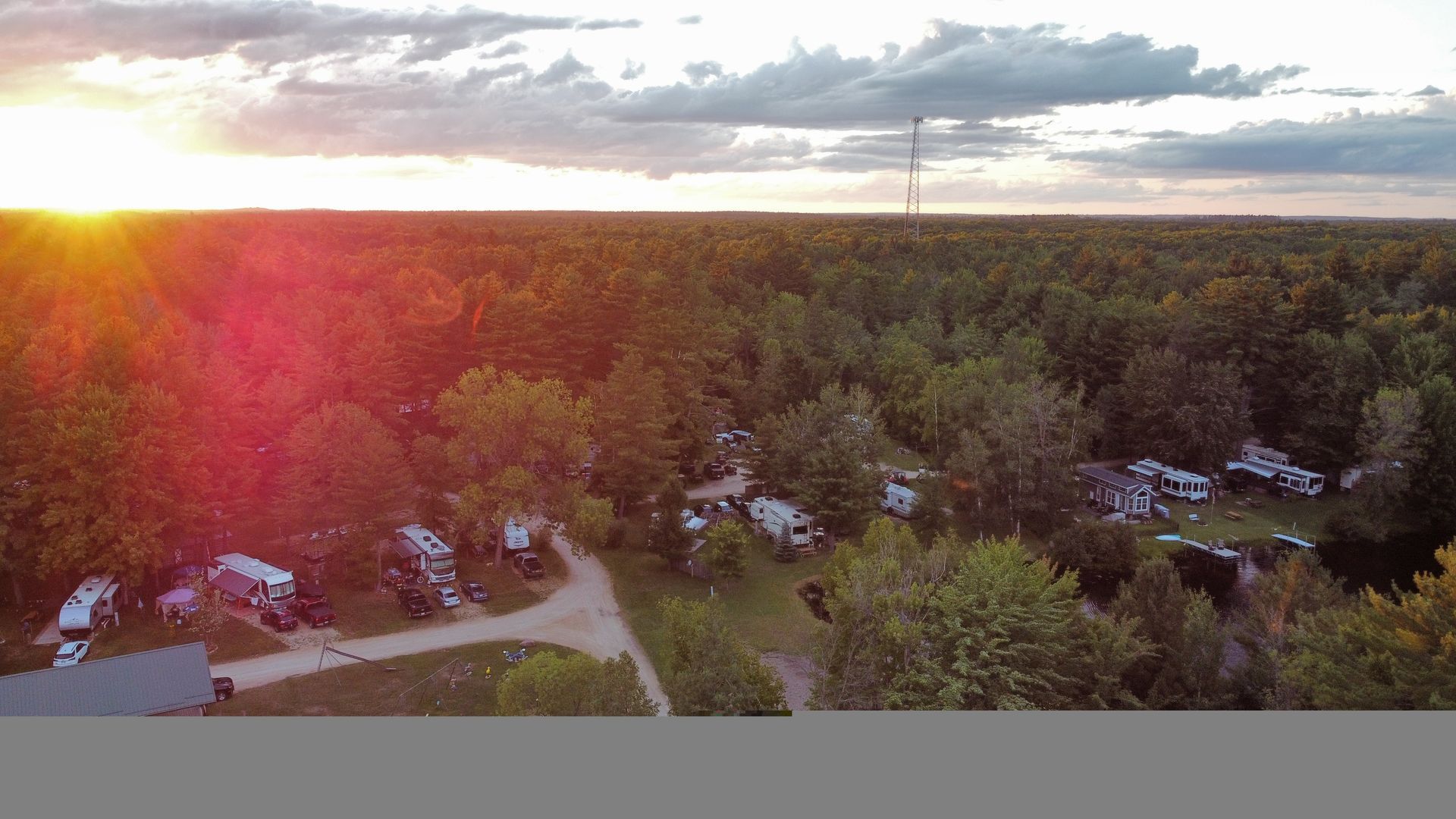 An aerial view of a campground with a sunset in the background.