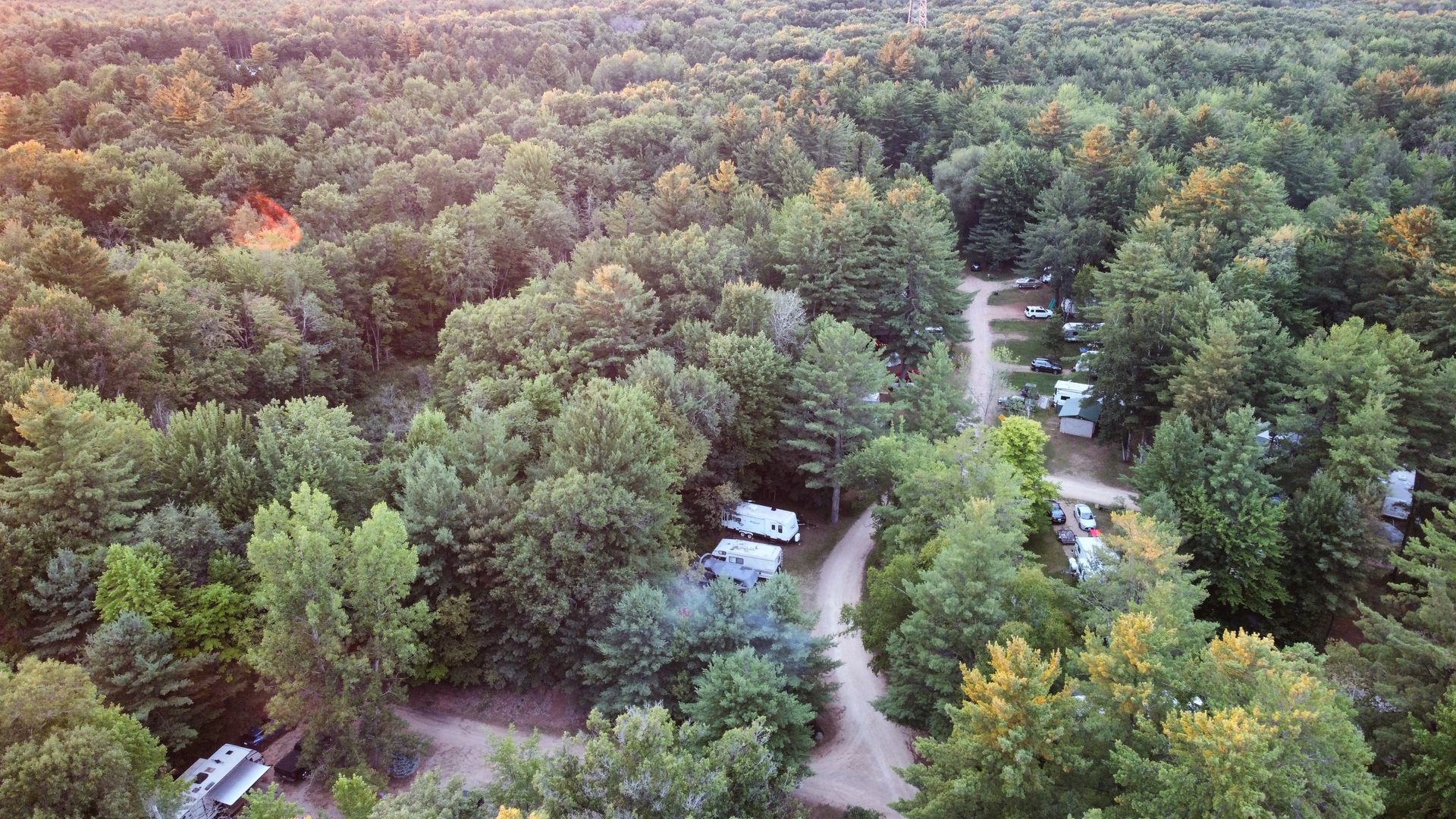 An aerial view of a campground in the middle of a forest.