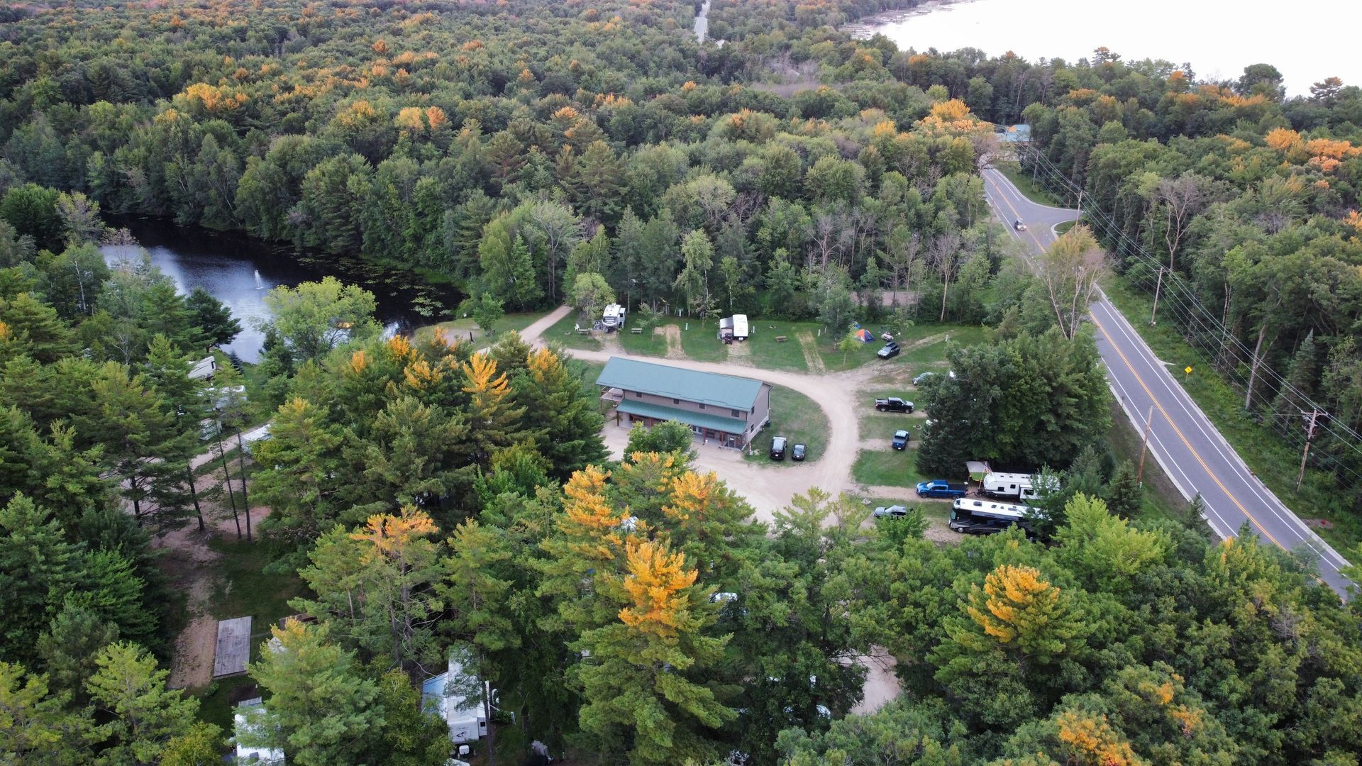 An aerial view of a campground surrounded by trees and a lake.