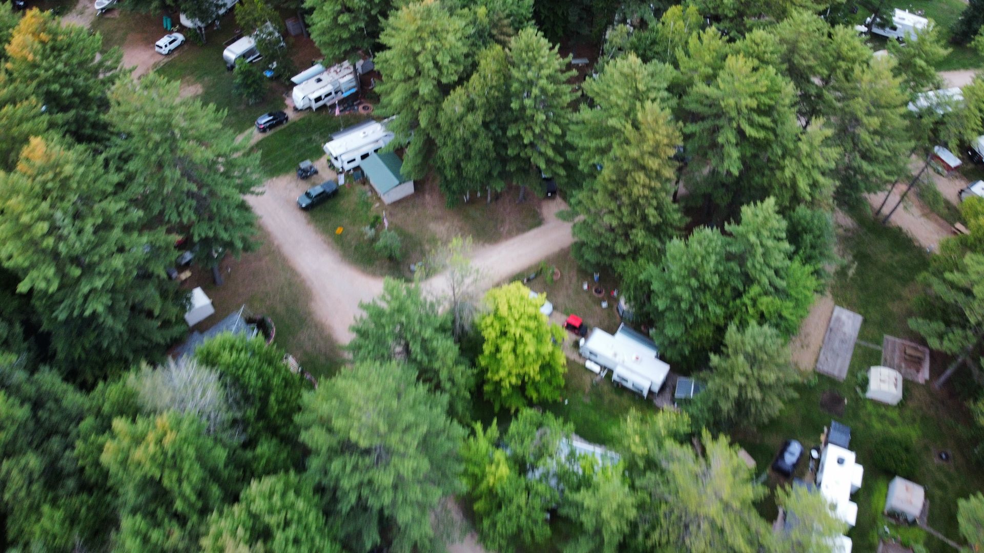 An aerial view of a campground surrounded by trees and rvs.