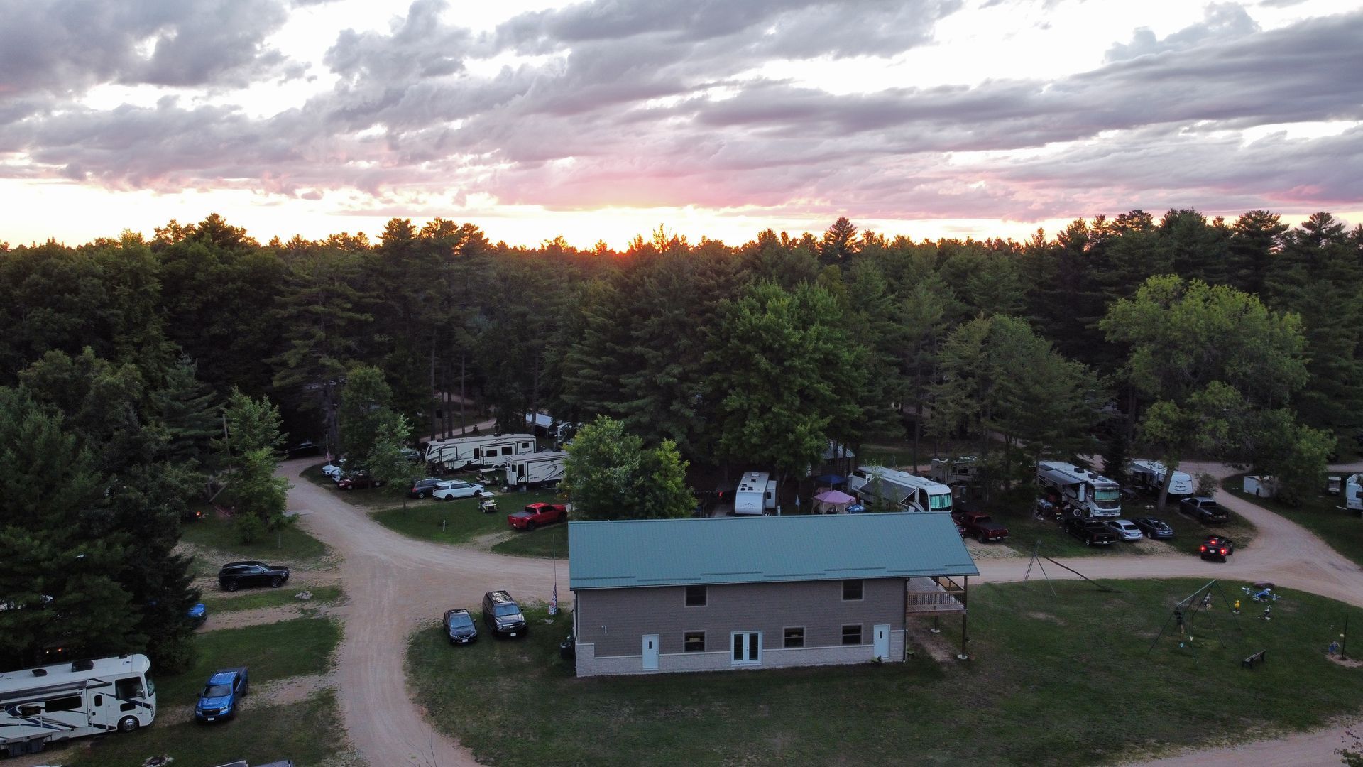 An aerial view of a campground with a sunset in the background.