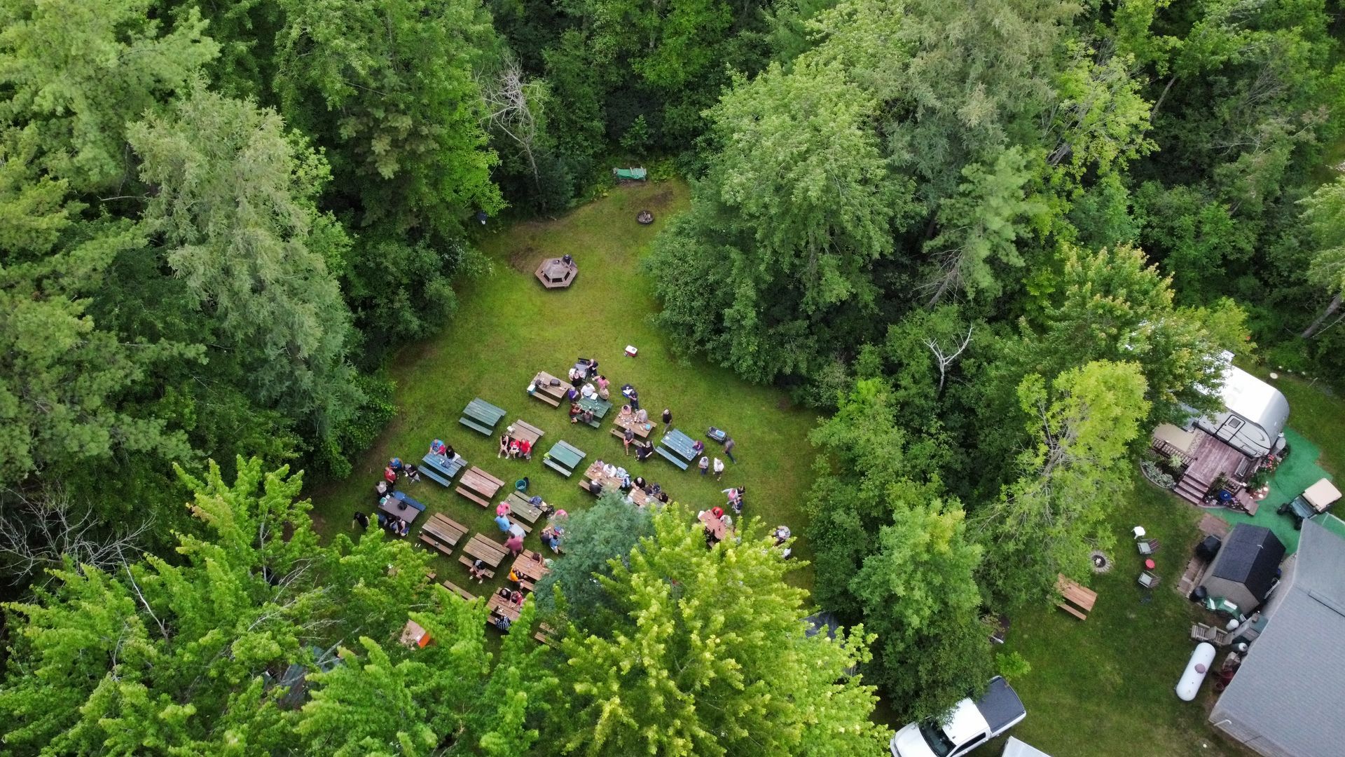 An aerial view of a picnic area in the middle of a forest.