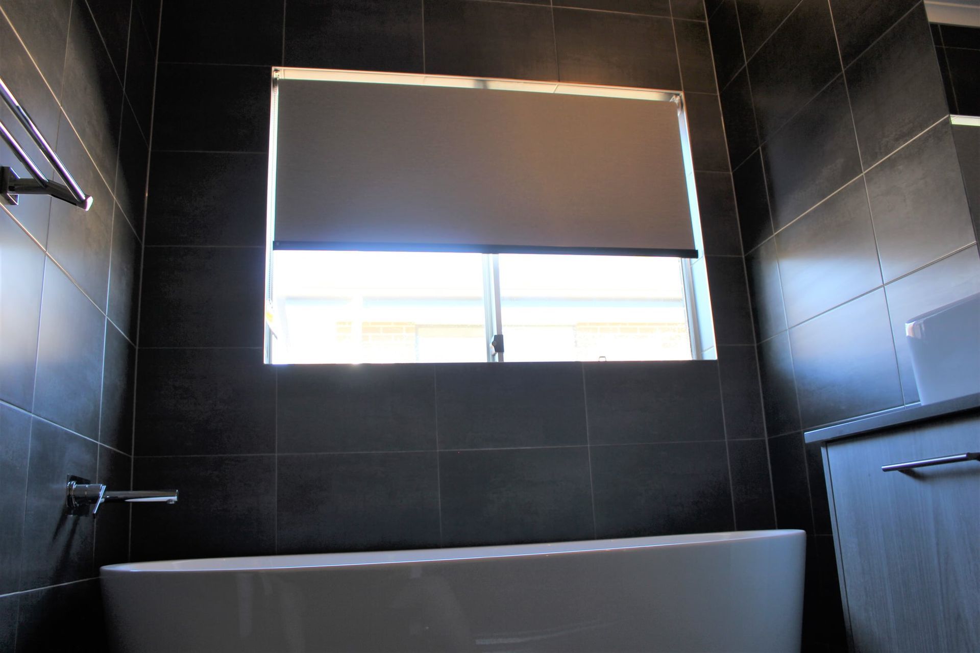 A Bathroom With A Tub And A Window With Blinds — Maxview Blinds and Shutters in Beresfield, NSW