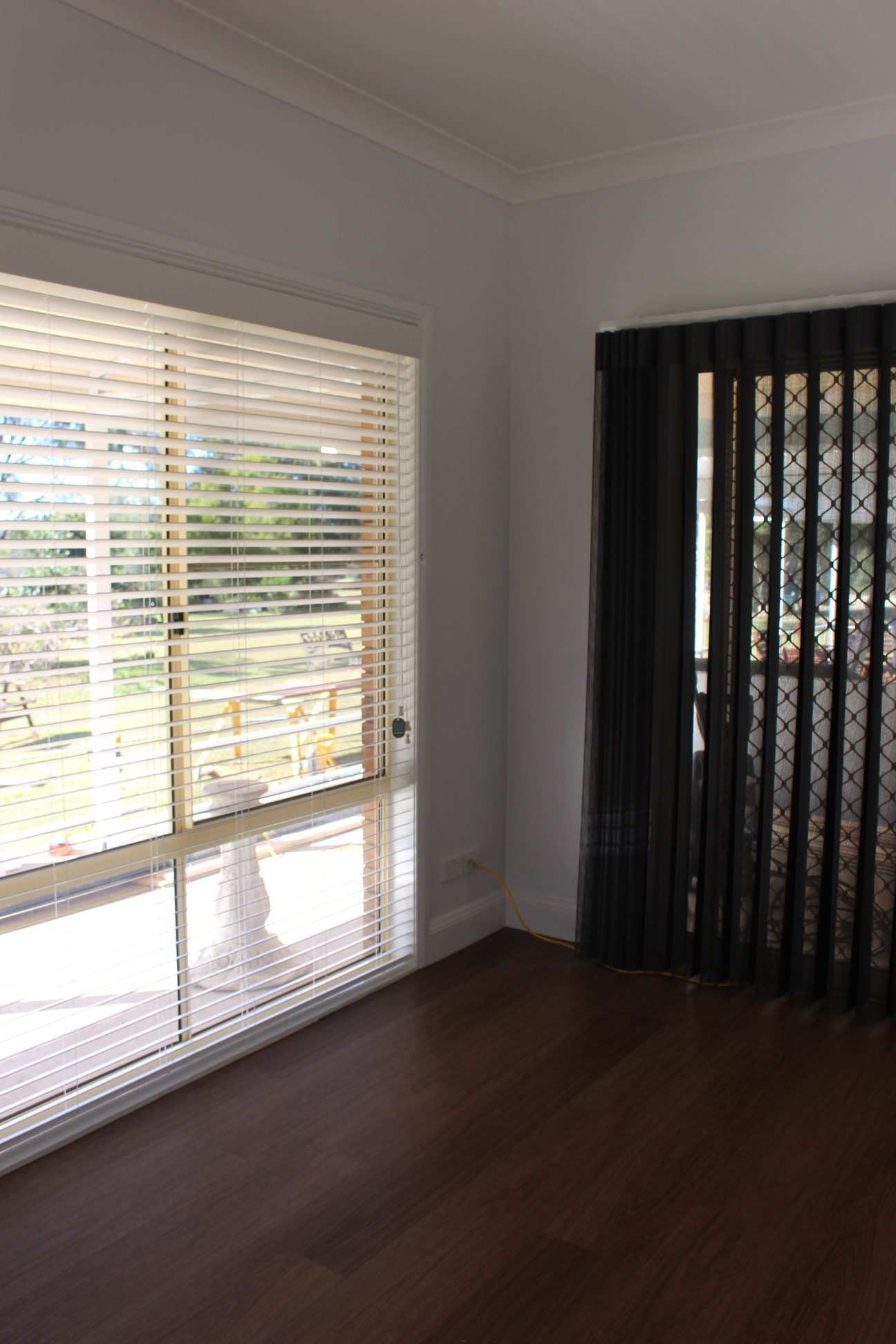 An Empty Room With A Sliding Glass Door And Blinds — Maxview Blinds and Shutters in Beresfield, NSW