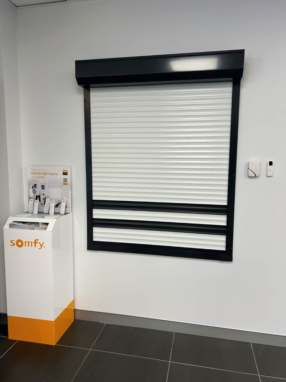 Room With A Window Roller Shutter And A Box That Says Somfy On It — Maxview Blinds and Shutters in Hunter Valley, NSW