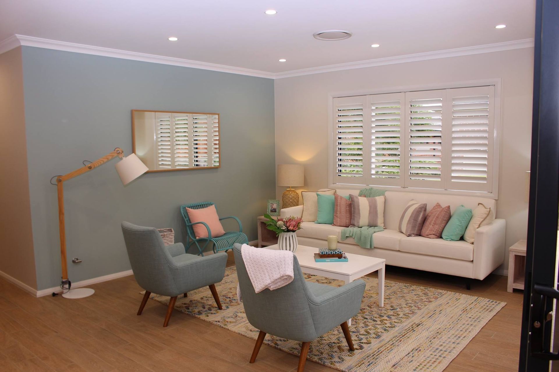 A Bedroom With A Window Featuring Black Shutters And A Potted Plant — Maxview Blinds and Shutters in Beresfield, NSW