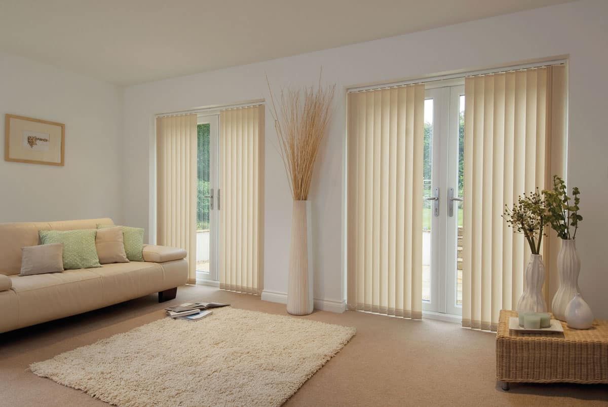 A Living Room With A Couch, Rug, And Vertical Blinds — Maxview Blinds and Shutters in Beresfield, NSW