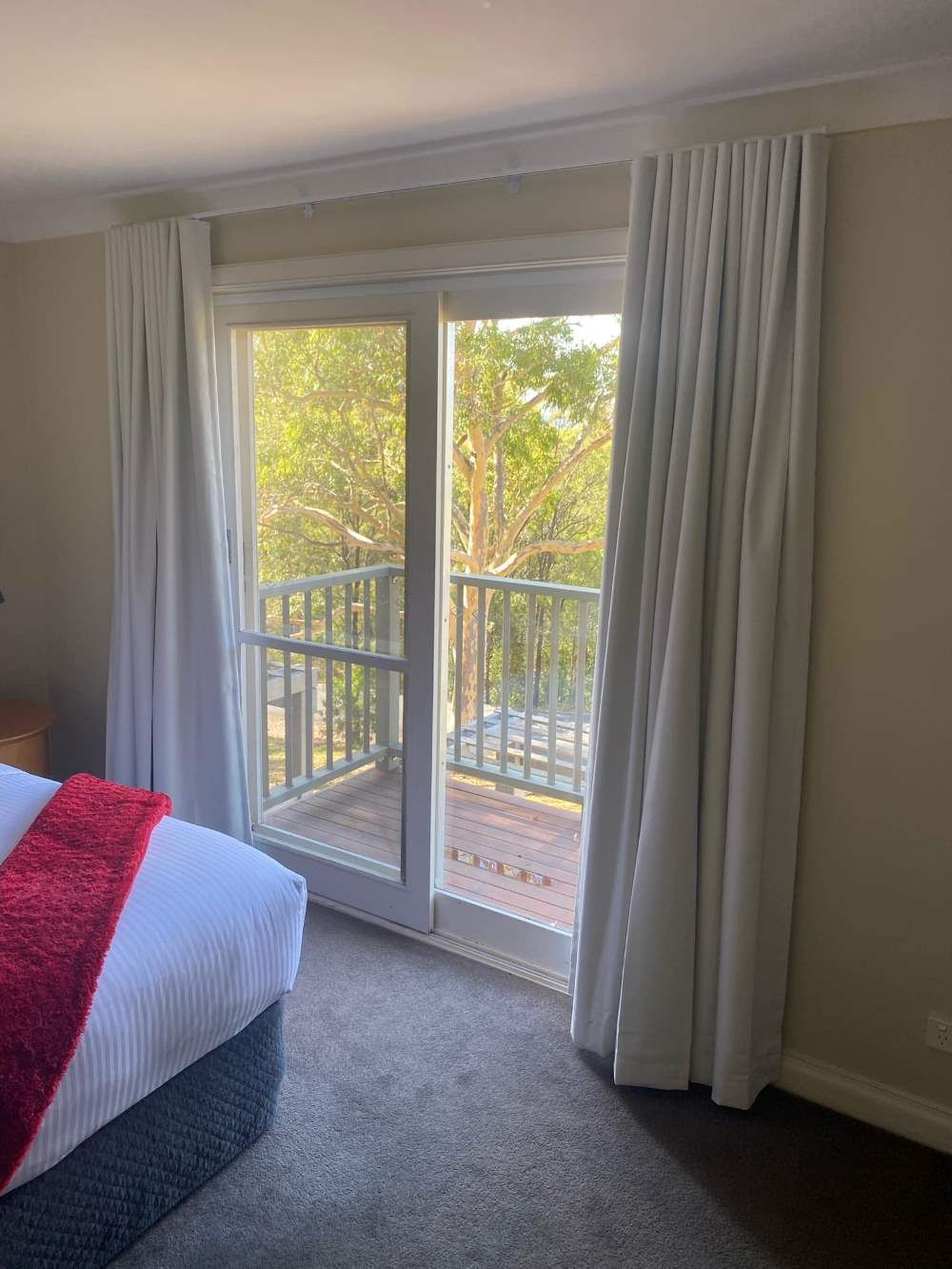 A Bedroom With Two Big Curtains On The Window — Maxview Blinds and Shutters in Beresfield, NSW