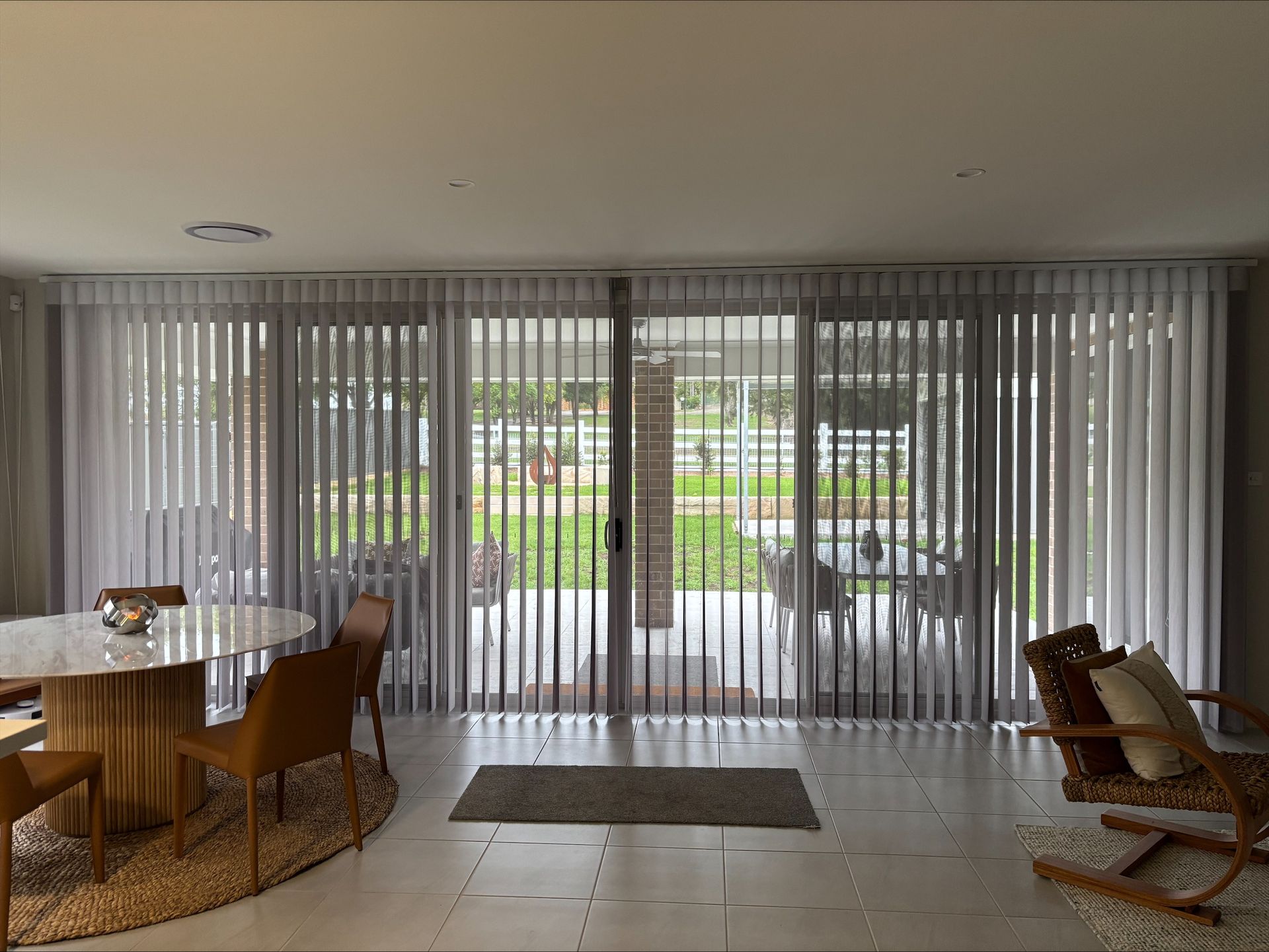 Bedroom With White Vertical Blinds And A Leopard Print Blanket — Maxview Blinds and Shutters in Beresfield, NSW