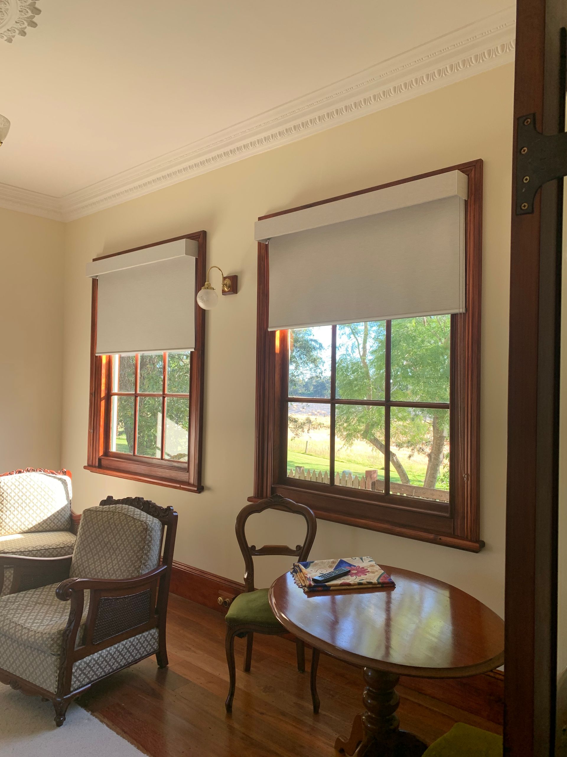 A living room with a table and chairs and two windows