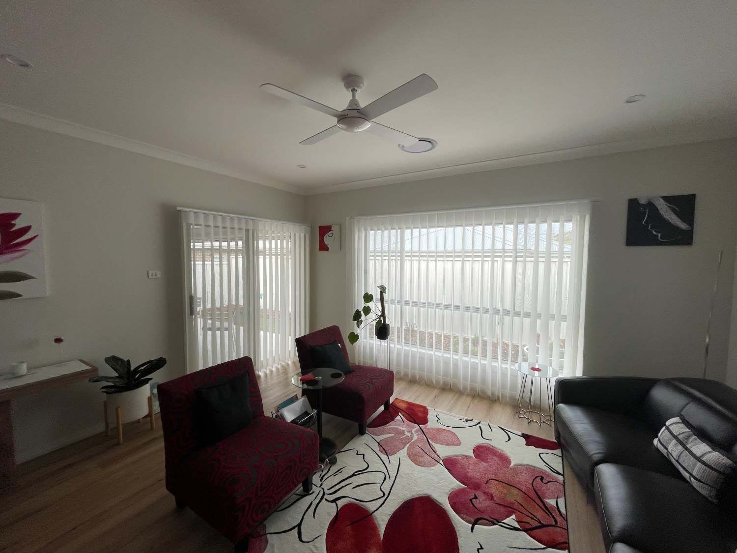 A Living Room With Two Windows Draped With White Curtains — Maxview Blinds and Shutters in Beresfield, NSW