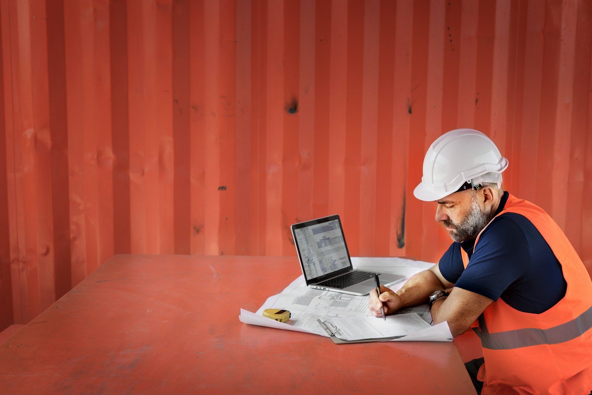 builder writing and with a laptop