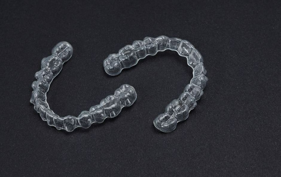 A close-up of clear Invisalign braces being used for teeth straightening.