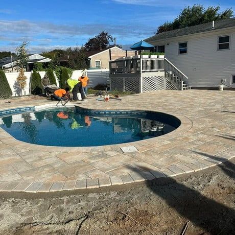 A swimming pool is being built in the backyard of a house.