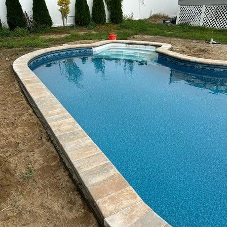 A large swimming pool is being built in a backyard.