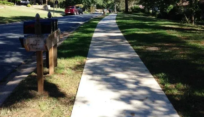 A sidewalk with a mailbox on the side of it