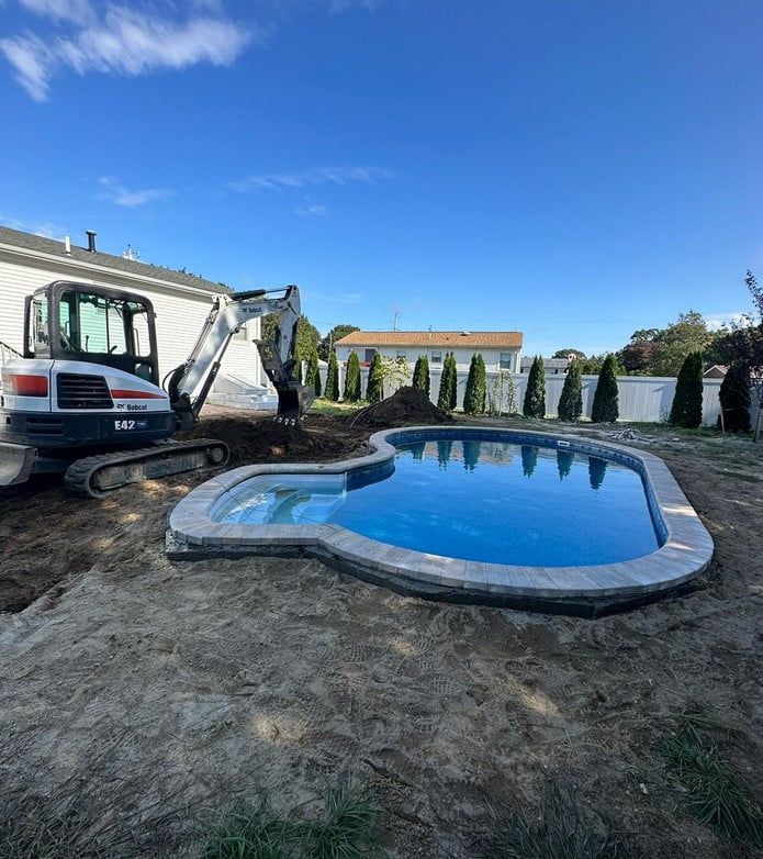 A large swimming pool is being built in a backyard.